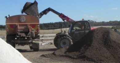 tractor piles manure and lime into waiting truck